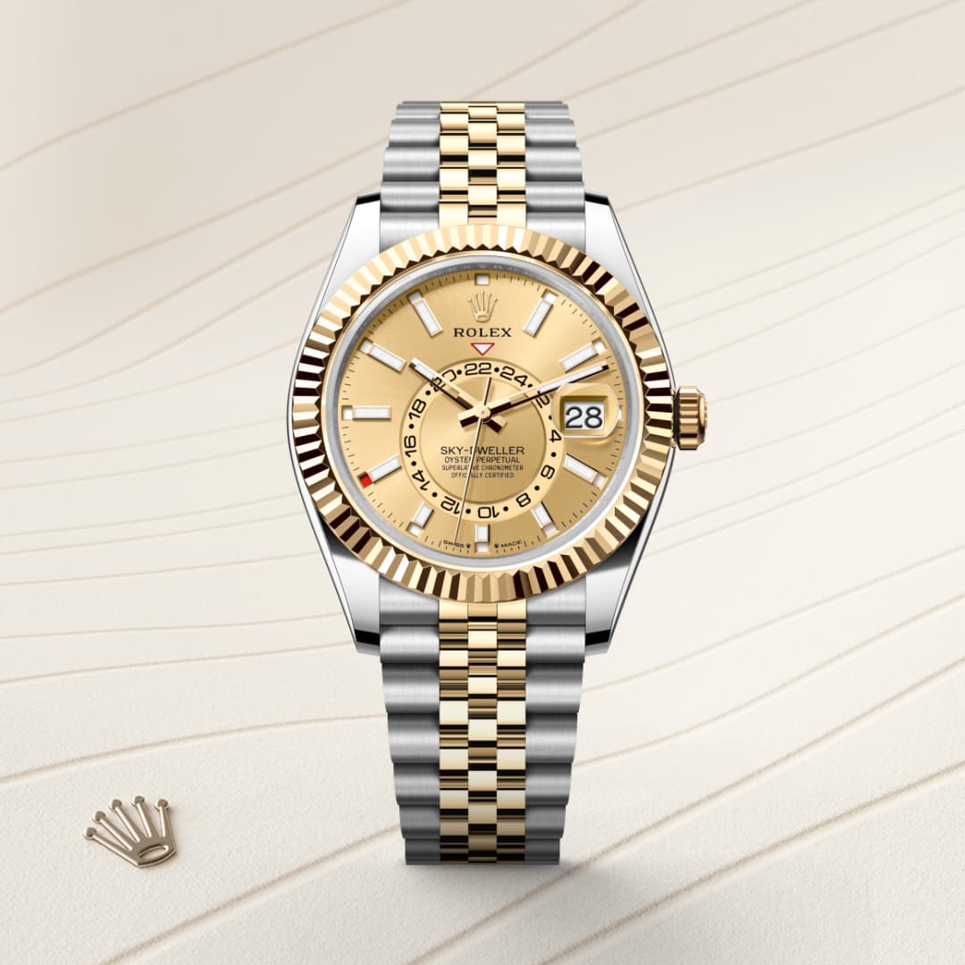 A gold and silver Rolex Sky-Dweller watch with a beige dial, displayed on a patterned background.
