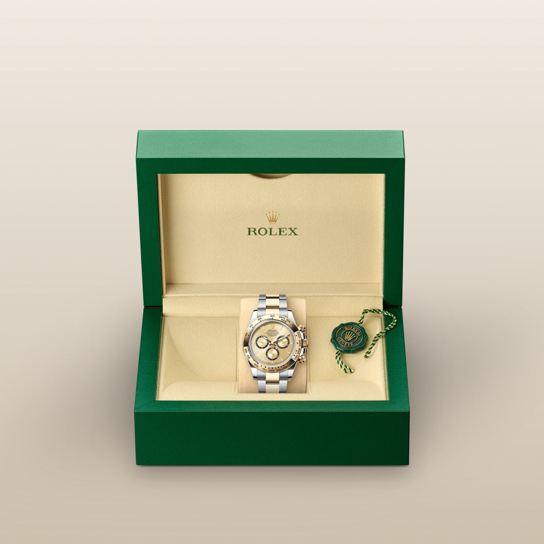 A Rolex watch in a green and cream box with a tag inside, displayed against a neutral background.
