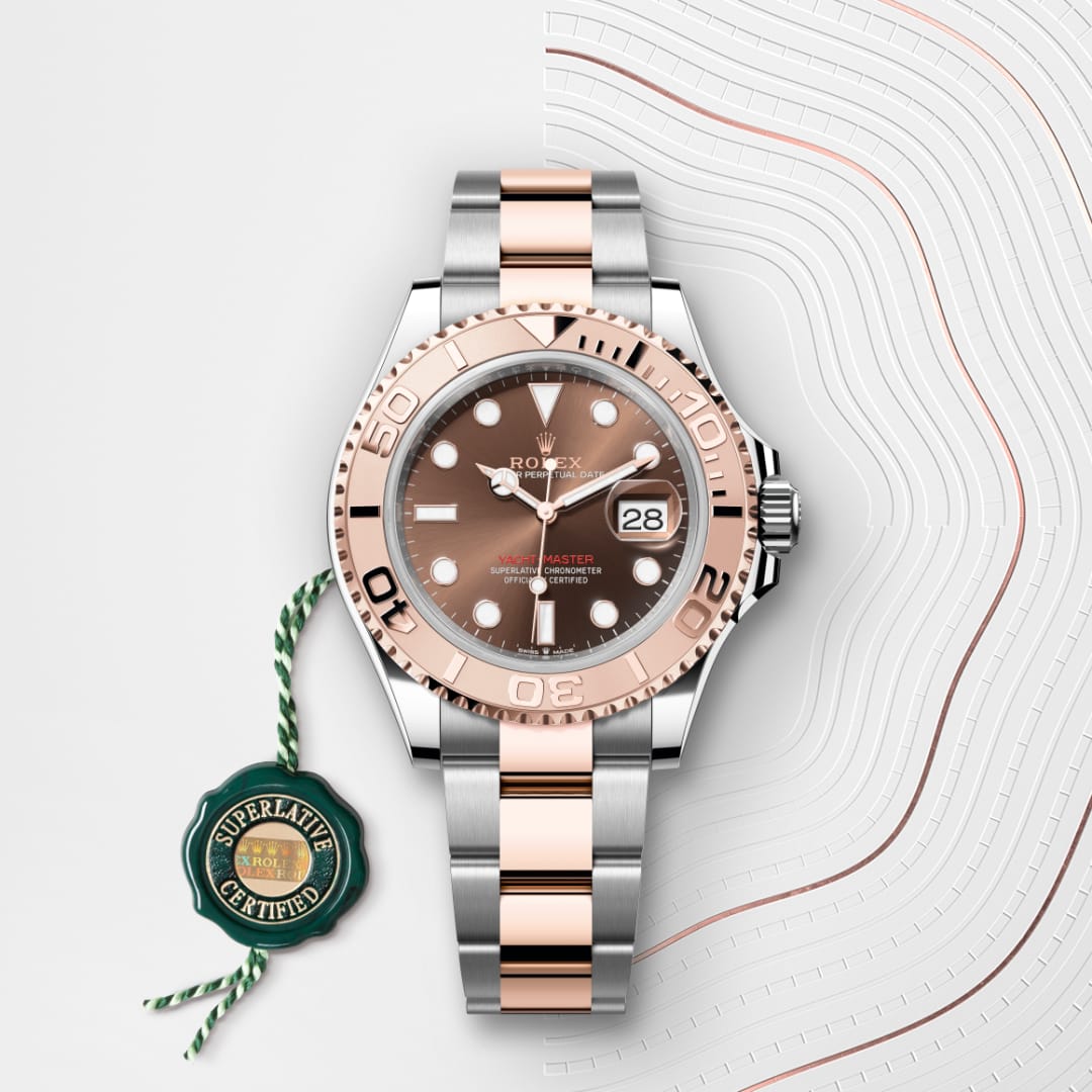 A Rolex watch with a silver and rose gold band, black dial, and date display, on a patterned white background.