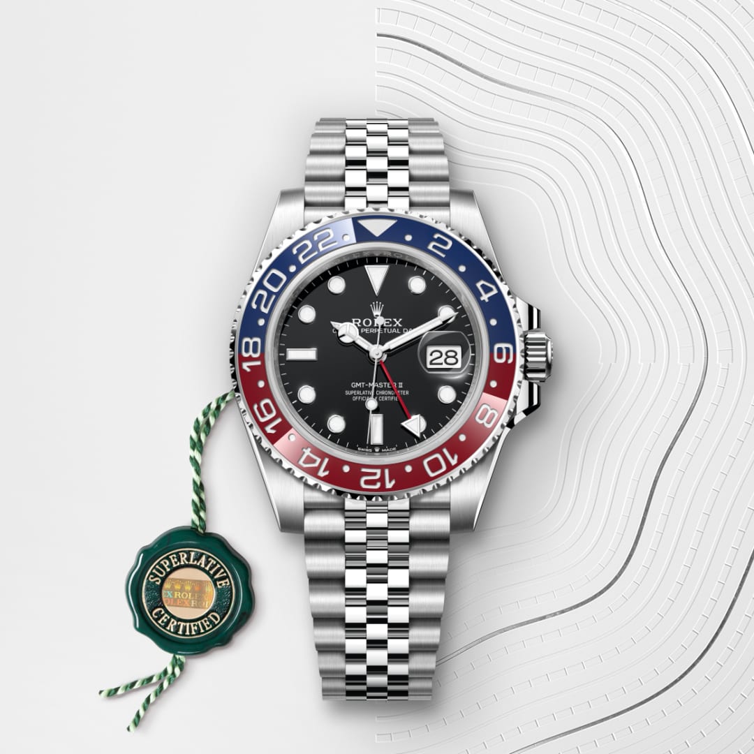 A Rolex GMT-Master II watch with a red and blue bezel, jubilee bracelet, and Superlative Certified tag.