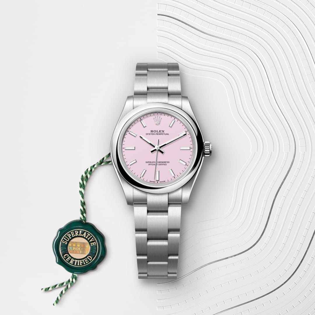 A silver Rolex watch with a pink dial and certification tag on a white patterned background.