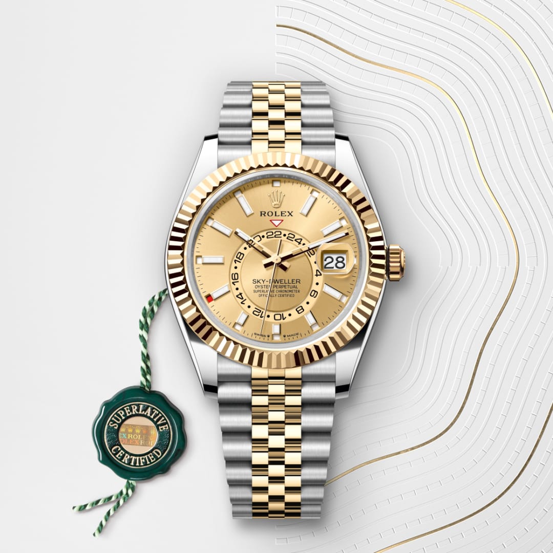 Gold and silver Rolex Sky-Dweller watch with date display, next to a green Superlative Certified tag.