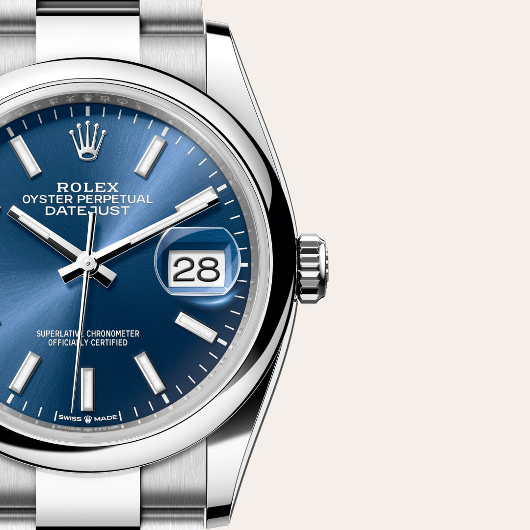Close-up of a Rolex Datejust watch with a blue dial, silver markers, and a visible date window showing 28.