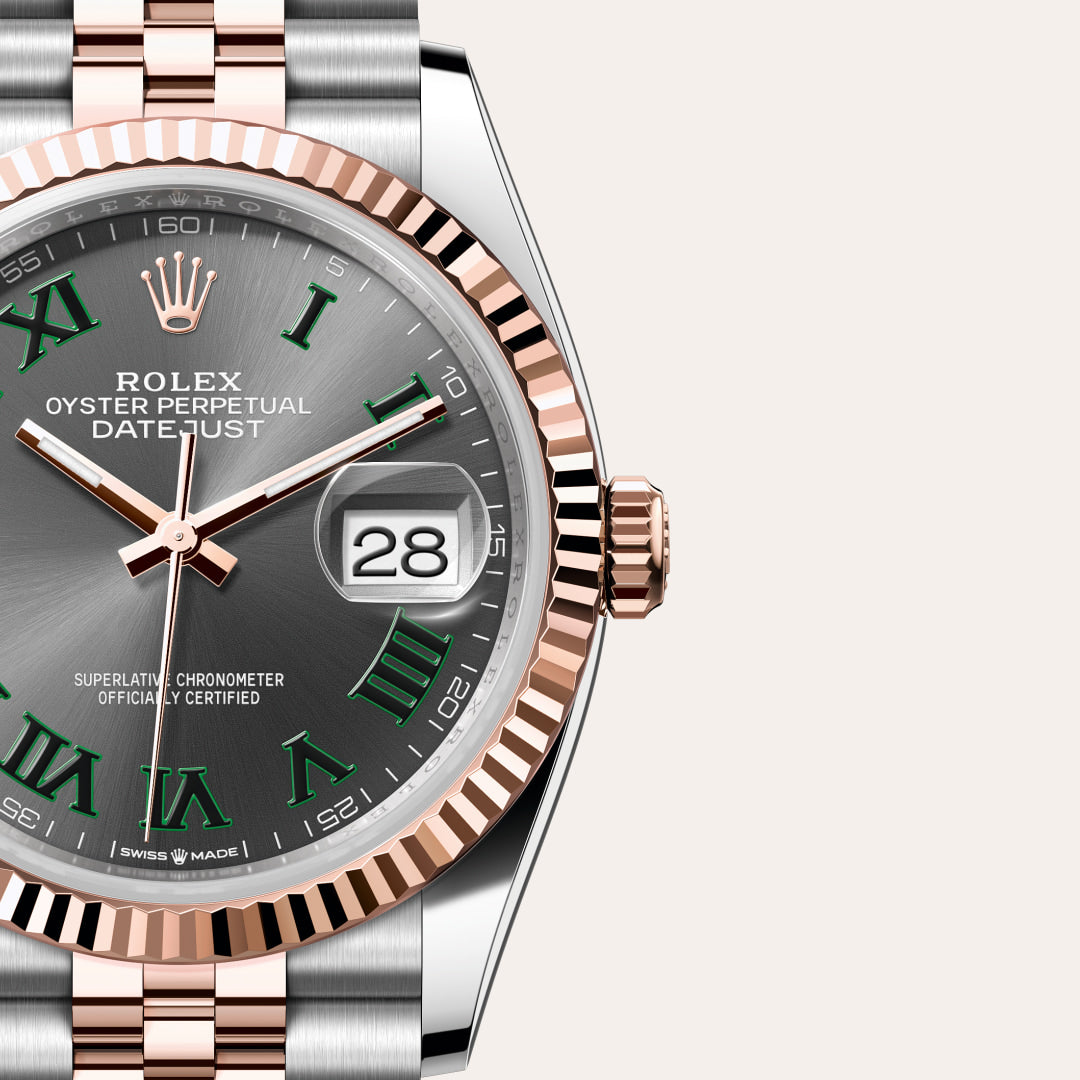 Close-up of a Rolex Datejust watch with a gray dial, green Roman numerals, and rose gold details.