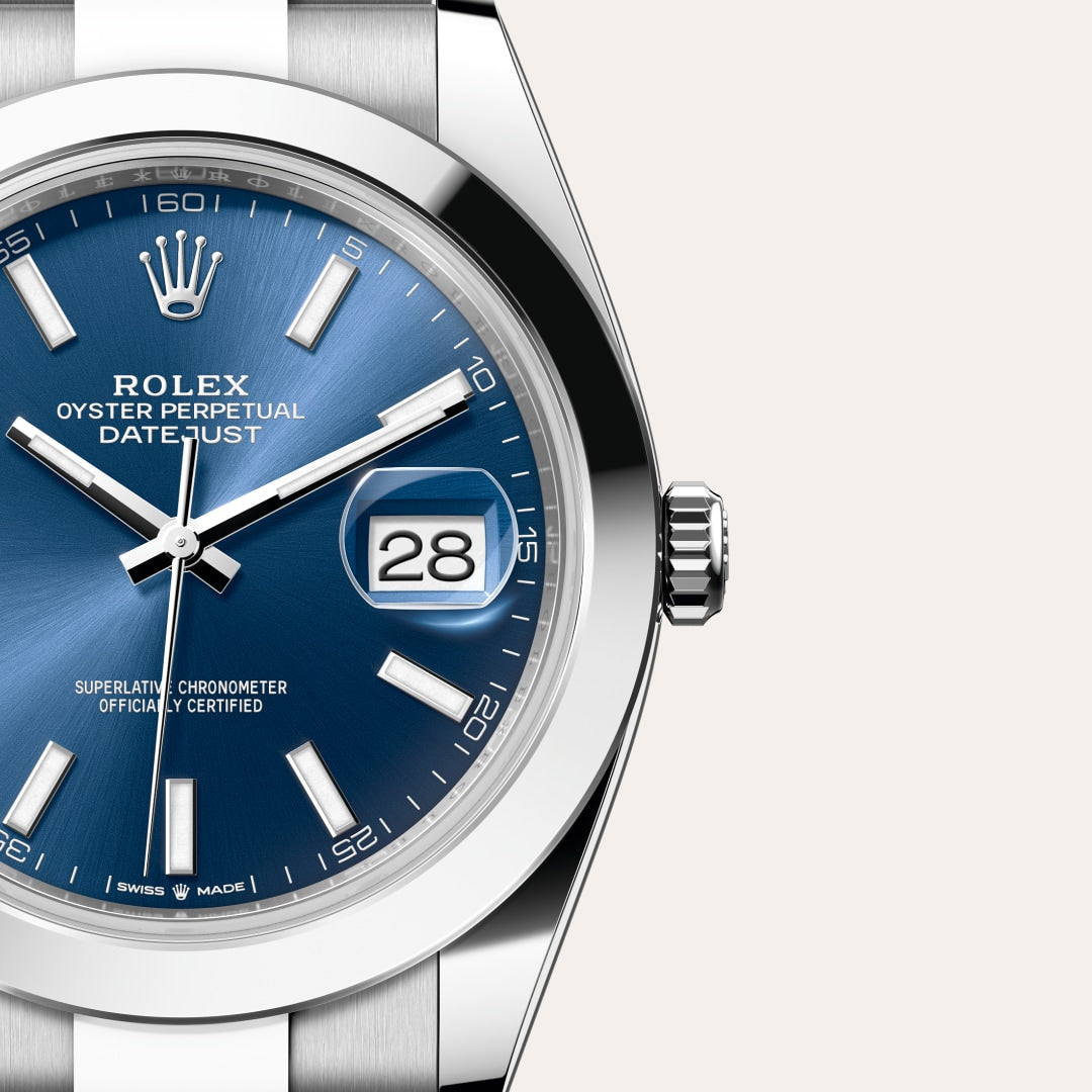 Close-up of a blue-dial Rolex Datejust watch showing the date as 28 and the time as 10:10.