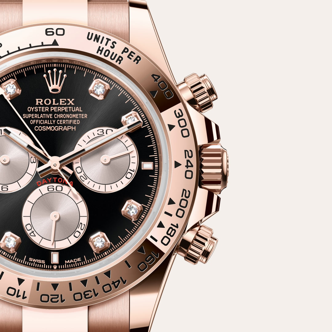 Close-up of a rose gold Rolex Daytona watch with a black dial and diamond hour markers.