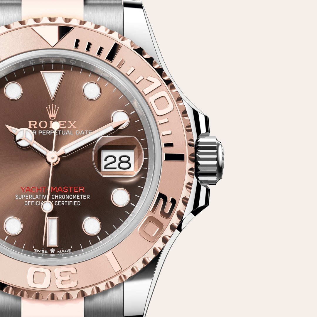 Close-up of a Rolex Yacht-Master watch with a rose gold bezel and brown dial showing the date at 28.