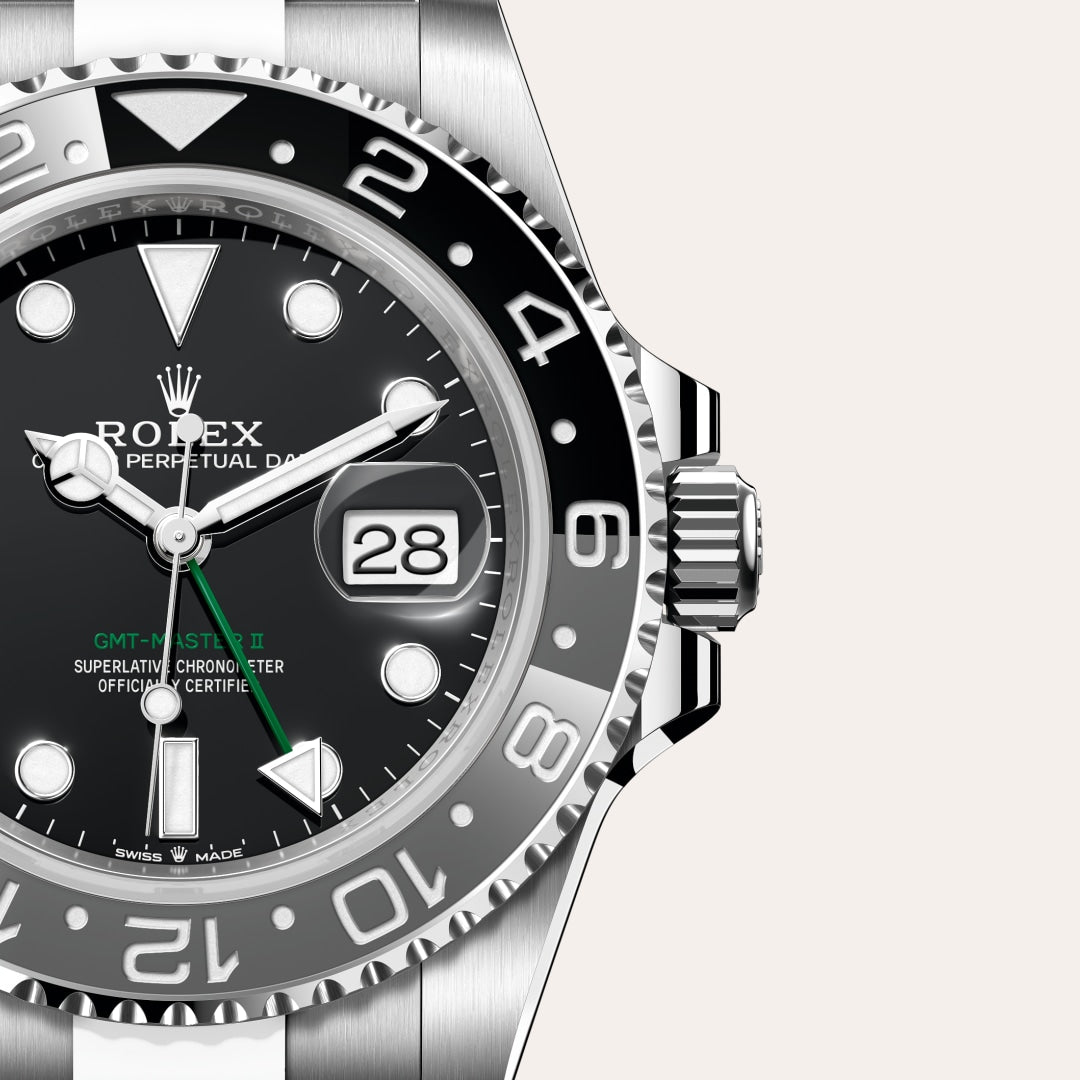 Close-up of a Rolex GMT-Master II watch showing its black dial, green GMT hand, and date window at 3 o’clock.