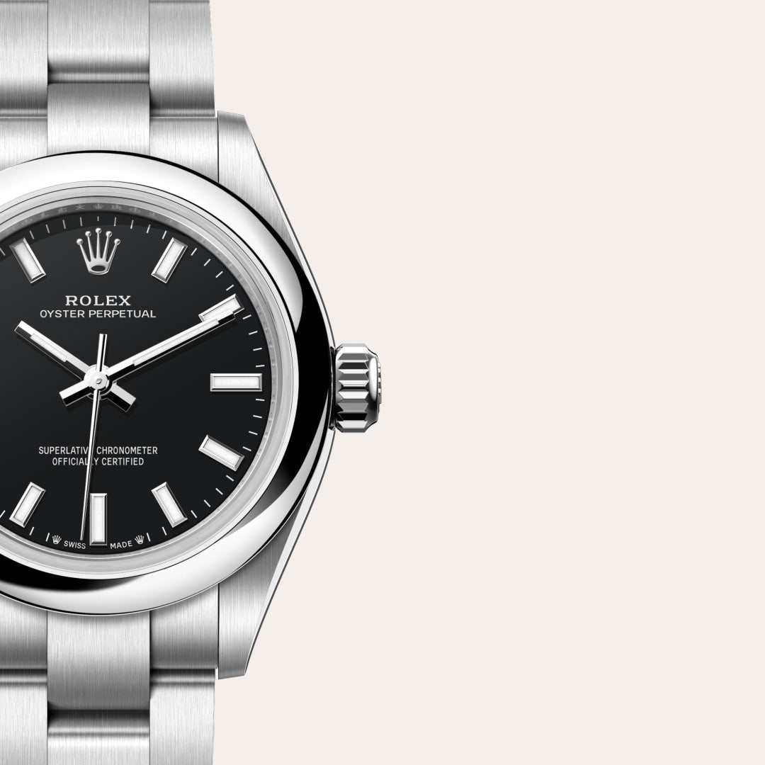 Close-up of a Rolex Oyster Perpetual watch with a black dial and silver metal strap on a light background.