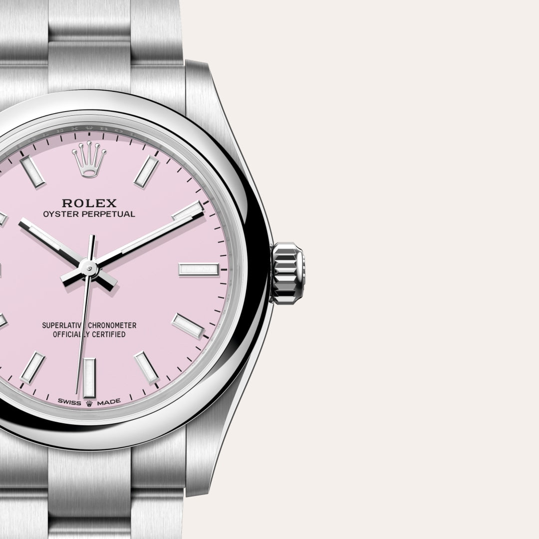 Silver Rolex watch with a pink dial and silver hour markers, shown against a plain light background.