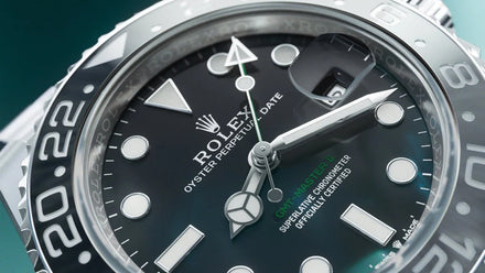 Close-up of a Rolex Oyster Perpetual GMT-Master II watch face with black dial and silver bezel.