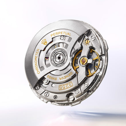 Close-up of a luxury Swiss watch movement with engraved gold text and intricate metal components.