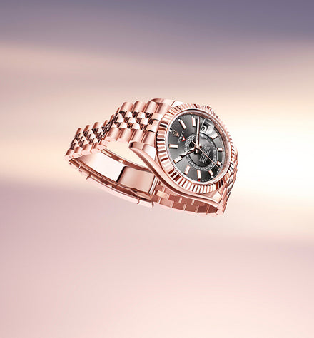 A rose gold wristwatch with a black dial and date display, floating against a soft gradient background.
