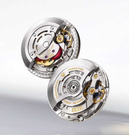 Close-up of two intricate Rolex watch movements, showing gears and engraved markings on silver components.