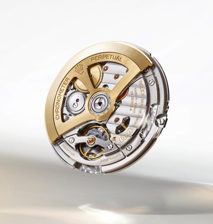 Close-up of a Rolex watch movement mechanism with gold and silver components and engraved text.