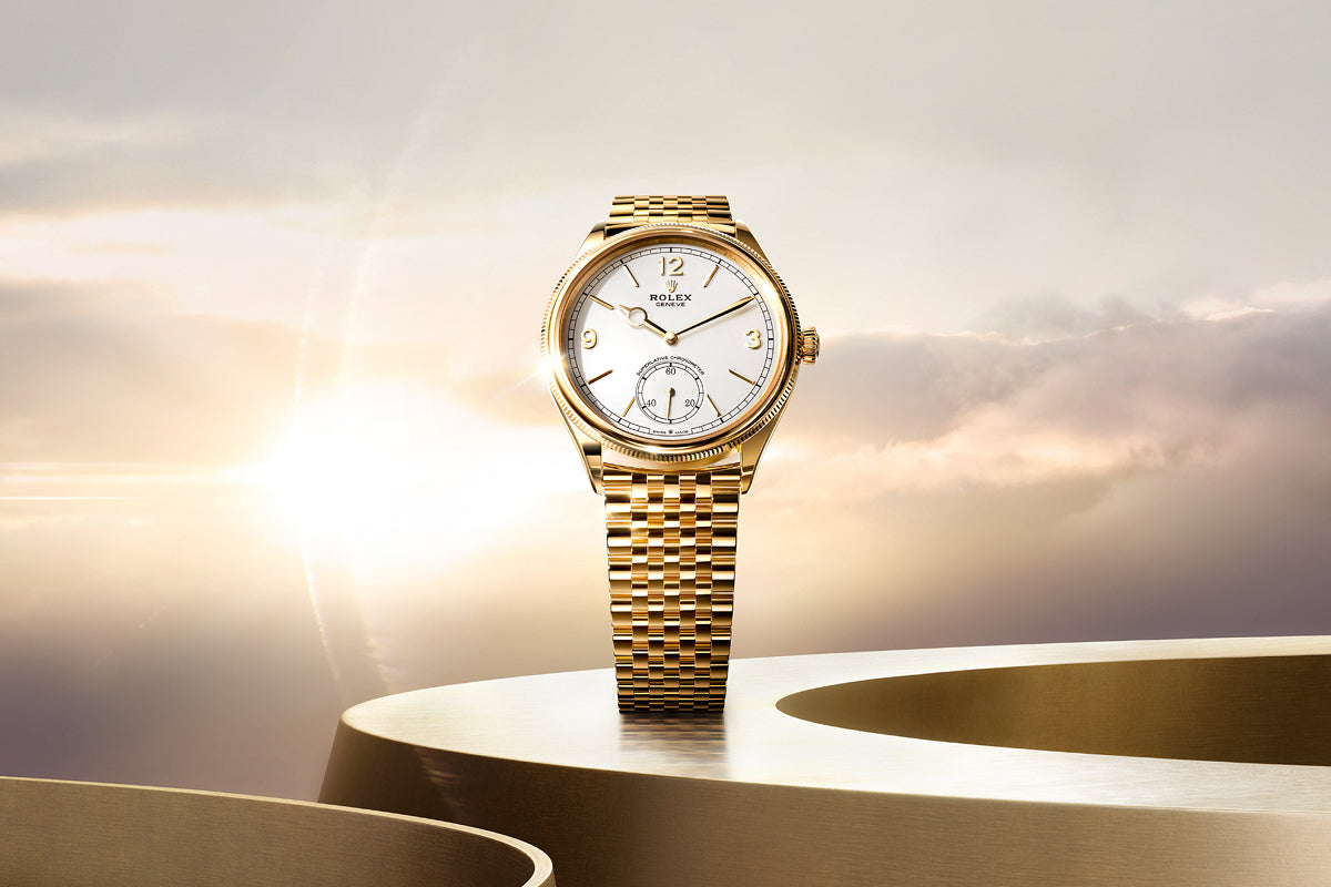 Gold Rolex watch with a white dial on a gold surface, set against a soft, sunlit sky background.