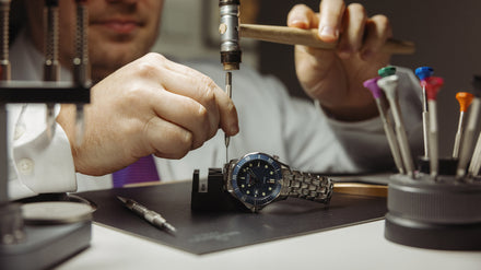 Watch Maker working on an OMEGA Seamaster timepiece at a desk