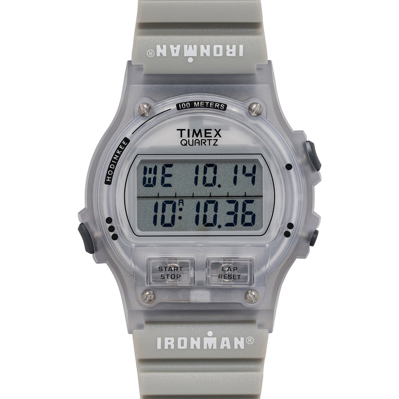 Timex Ironman digital watch with clear case and gray band on a white background