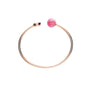 The Chopard Happy Diamonds Planet gold open-ended bracelet features a pink sphere inspired by Happy Diamonds jewelry, accented with a small gold cap at the other end, shown on a white background.