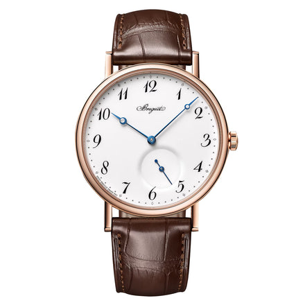 The Breguet Classique 7147 features a white grand feu enamel dial with black numerals, blue hands, brown leather strap, and a small seconds subdial at 6 o’clock—a refined tribute to Breguet’s timeless design.