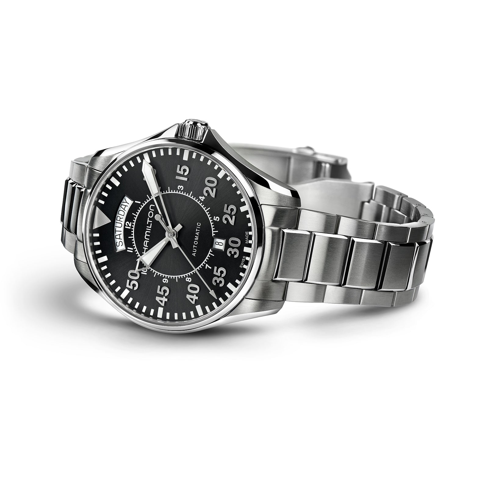 The Hamilton Khaki Aviation Pilot Day Date Auto is a stainless steel aviator wristwatch featuring a black dial with white numerals, day and date display, automatic movement, and a metal bracelet, shown angled slightly to the right.