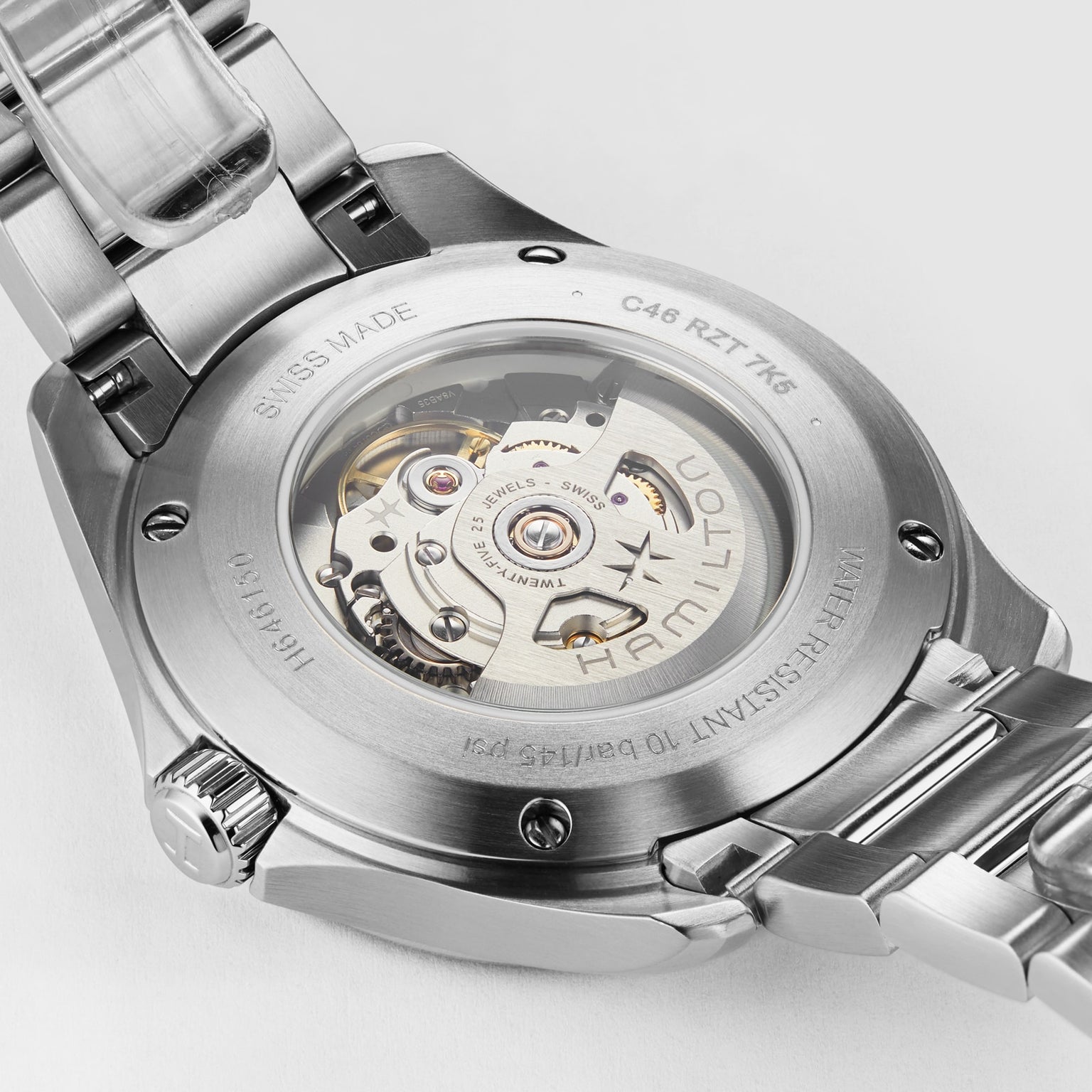 Close-up of the back of a Hamilton Khaki Aviation Pilot Day Date Auto wristwatch, featuring a transparent caseback that reveals the automatic movement and engravings denoting specifications and Swiss origin.