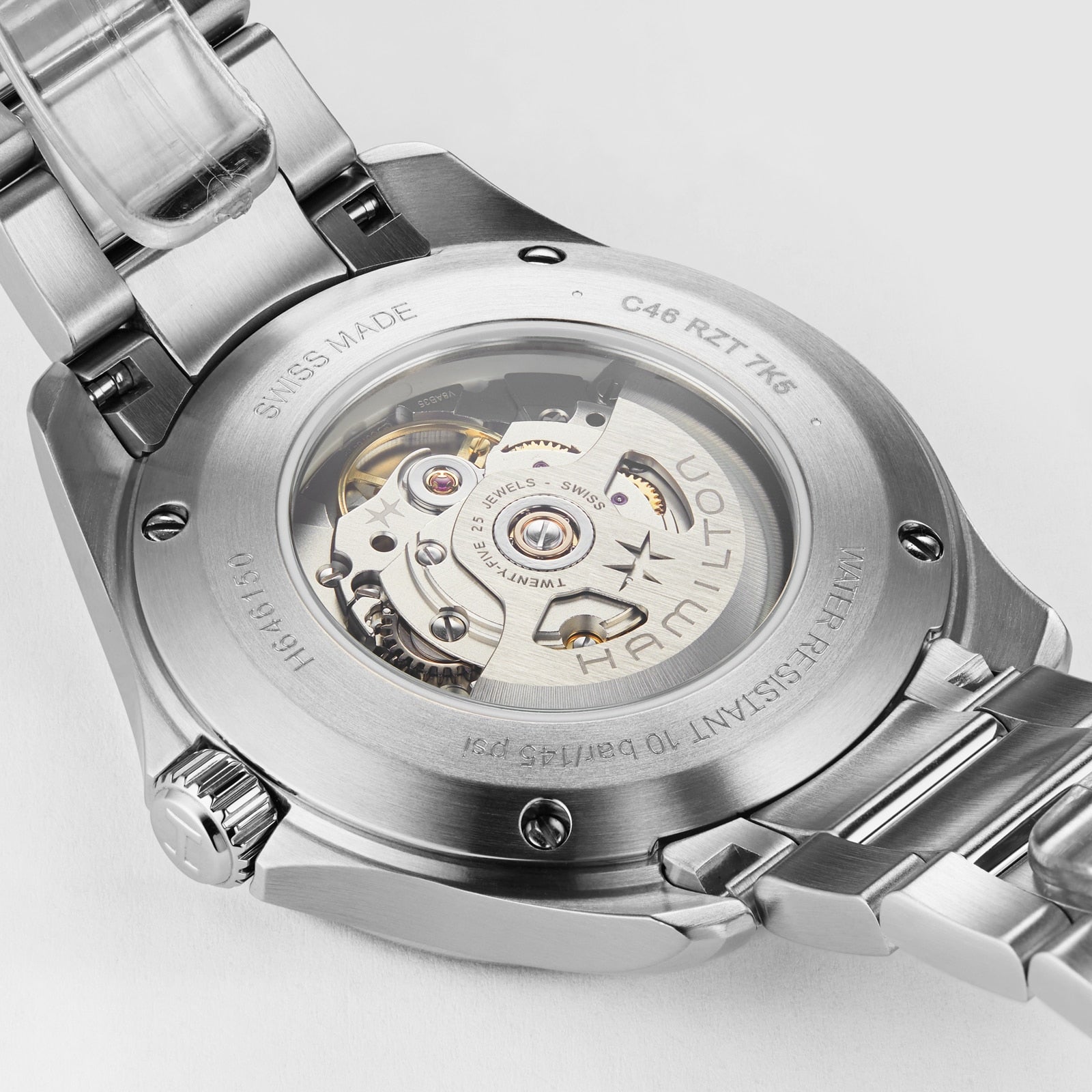 Close-up of the back of a Hamilton Khaki Aviation Pilot Day Date Auto wristwatch, featuring a transparent caseback that reveals the automatic movement and engravings denoting specifications and Swiss origin.
