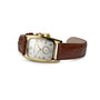 The Hamilton American Classic Boulton Quartz features a gold-tone case, square white dial, Swiss precision, brown leather strap, Arabic numerals at 12, 3, and 9 o’clock, and a small subdial at 6.