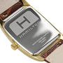 Close-up of the back of a Hamilton American Classic Boulton Quartz with a brown leather strap, gold-tone case, and engraved branding that highlights Swiss precision and detailed specifications.