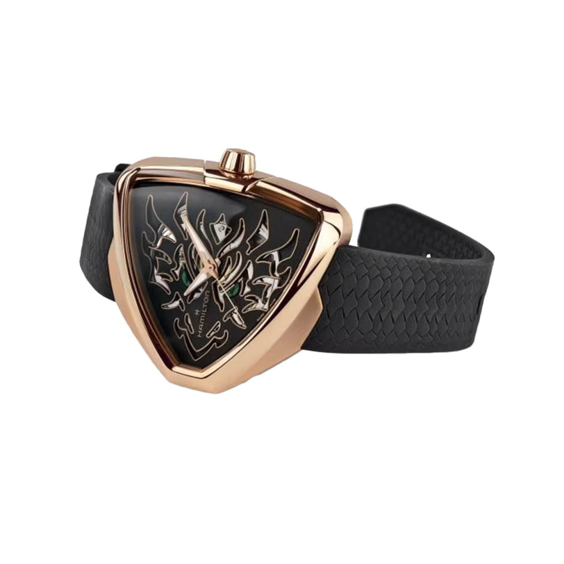 The Hamilton Khaki Field King Auto is a black and gold triangular wristwatch featuring a tribal design on the face and a textured black strap.