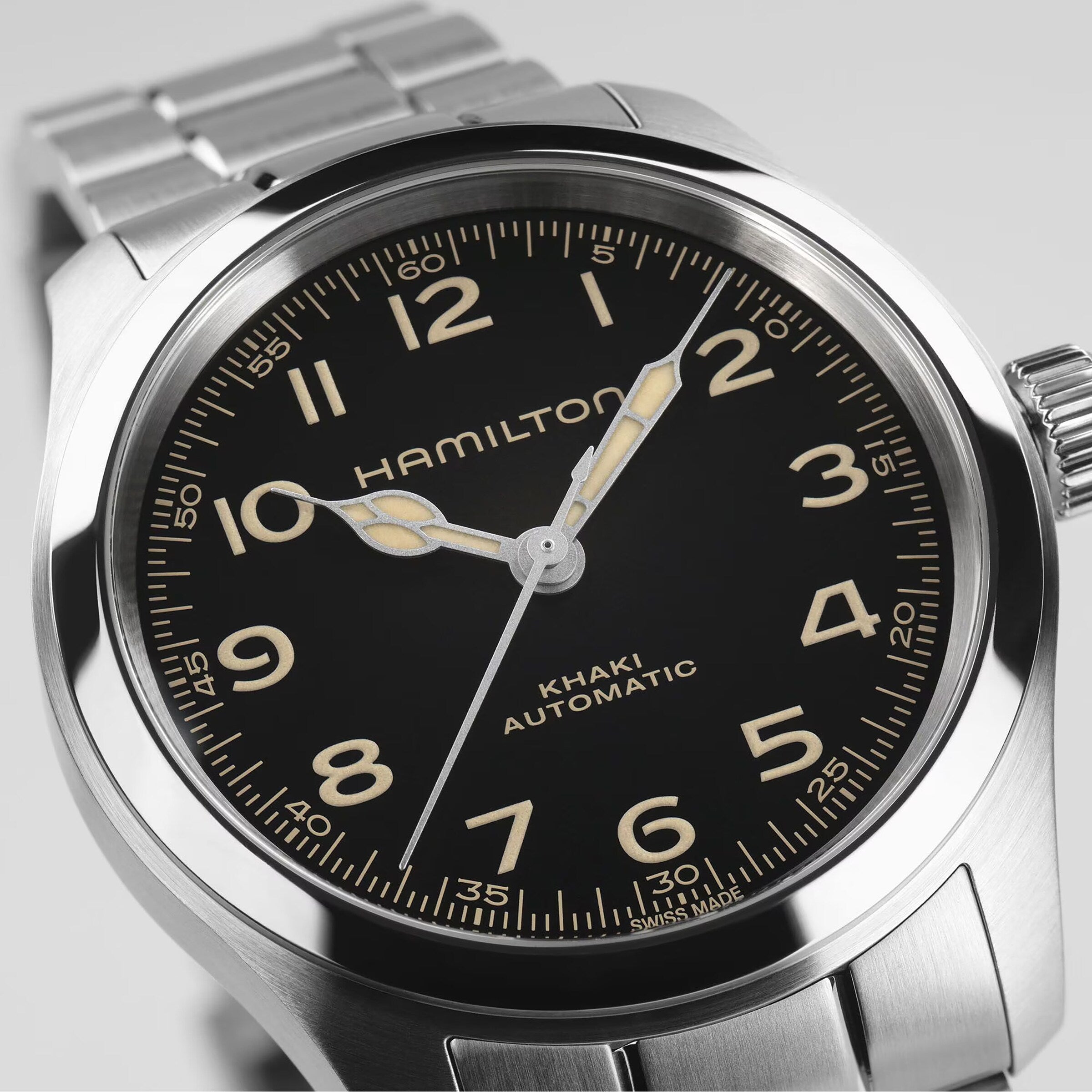 Close-up of the Hamilton Khaki Field Murph 38mm, featuring a black dial, luminous hands, Arabic numerals, and a stainless steel bracelet—a modern interpretation of this classic timepiece.