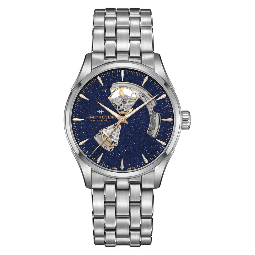 The Hamilton Jazzmaster Open Heart Auto 42mm features a stainless steel case, blue textured dial with gold hands, visible internal mechanism, automatic movement, and a metal link band—a striking choice in contemporary dress watches.