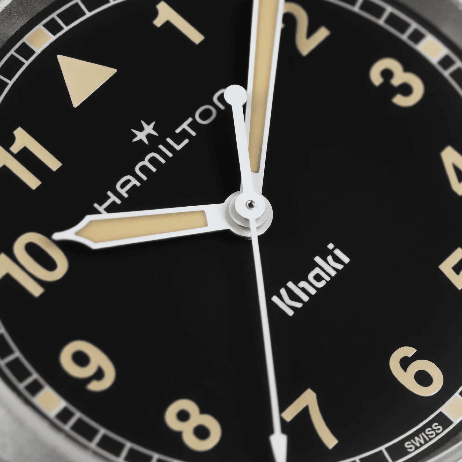 Close-up of the Hamilton Khaki Field Quartz 33mm watch face at 10:10:30, featuring beige hour markers and hands on a black dial—a durable, exploration-ready timepiece.