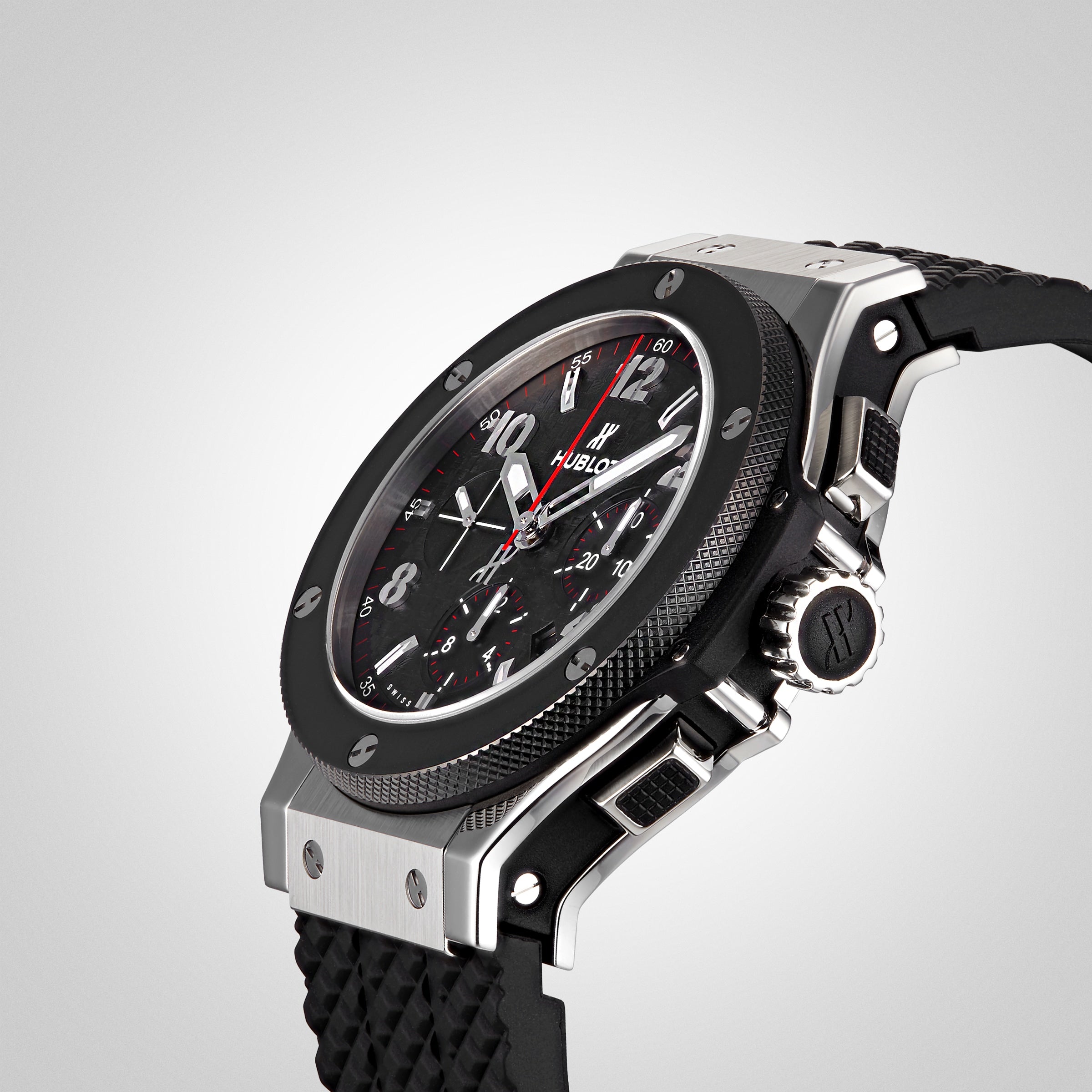 A close-up of the Hublot Big Bang Original Steel Ceramic wristwatch, featuring a black and silver case, textured band, detailed analog face with multiple dials and red accents in an automatic chronograph design.