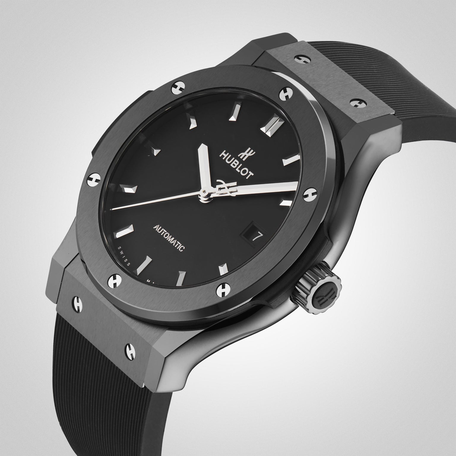 A close-up of the Hublot Classic Fusion Black Magic wristwatch showcases its black ceramic round face, silver markers, and black rubber strap against a light gray background.