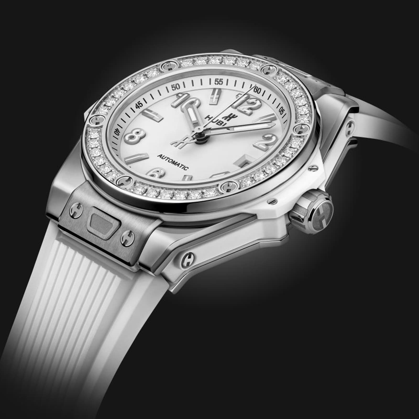 A Hublot Big Bang One Click Steel White Diamonds wristwatch with a white face, self-winding movement, diamond bezel, and white strap is elegantly displayed on a black background.