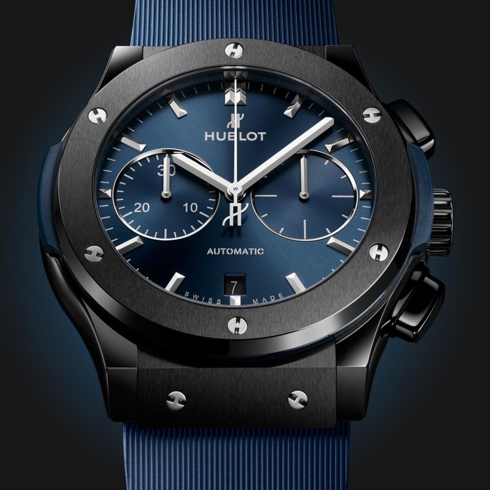 Close-up of a Hublot Classic Fusion Ceramic Blue Chronograph featuring a blue sunray dial with three subdials, date window, and blue strap. The watch has a brushed ceramic bezel with exposed screws.