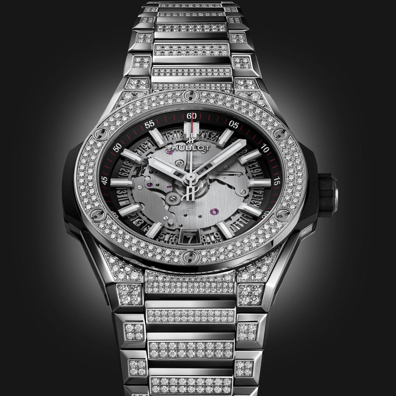 The Hublot Big Bang Integrated Time Only Titanium Pavé is a luxury watch with a titanium case and metal band set with diamonds, plus a partially skeletonized dial and visible gears, inspired by the Big Bang Integrated Time collection.