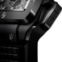 Close-up of the Hublot Square Bang Unico Black Magic wristwatch, showing its case, crown, and textured strap with a sapphire crystal skeleton dial in the signature Square Bang design—set against a white backdrop.
