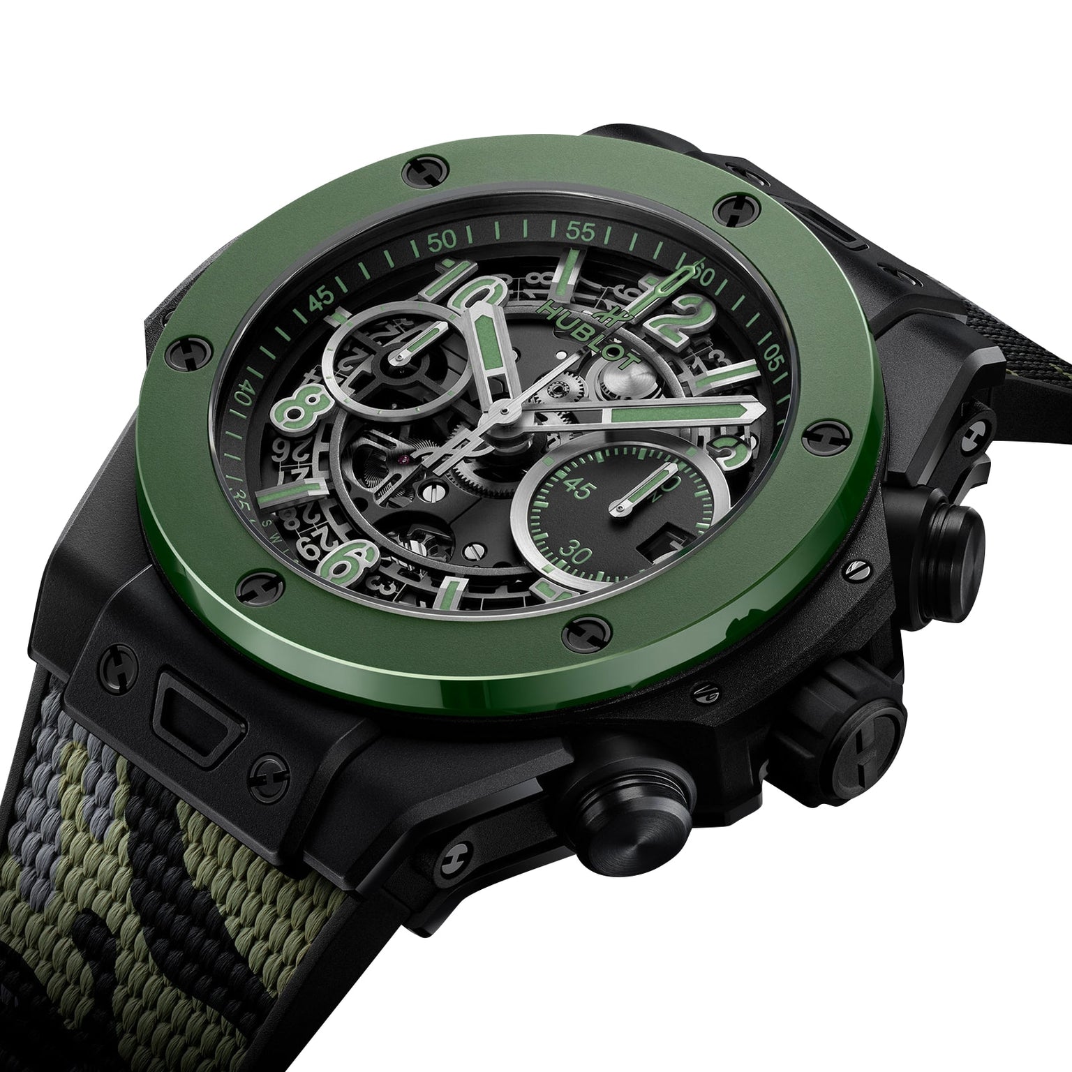 A close-up of the Hublot Big Bang Unico The Watches of Switzerland Group Exclusive, featuring a green bezel, skeleton dial, black case, and camouflage-patterned fabric strap.