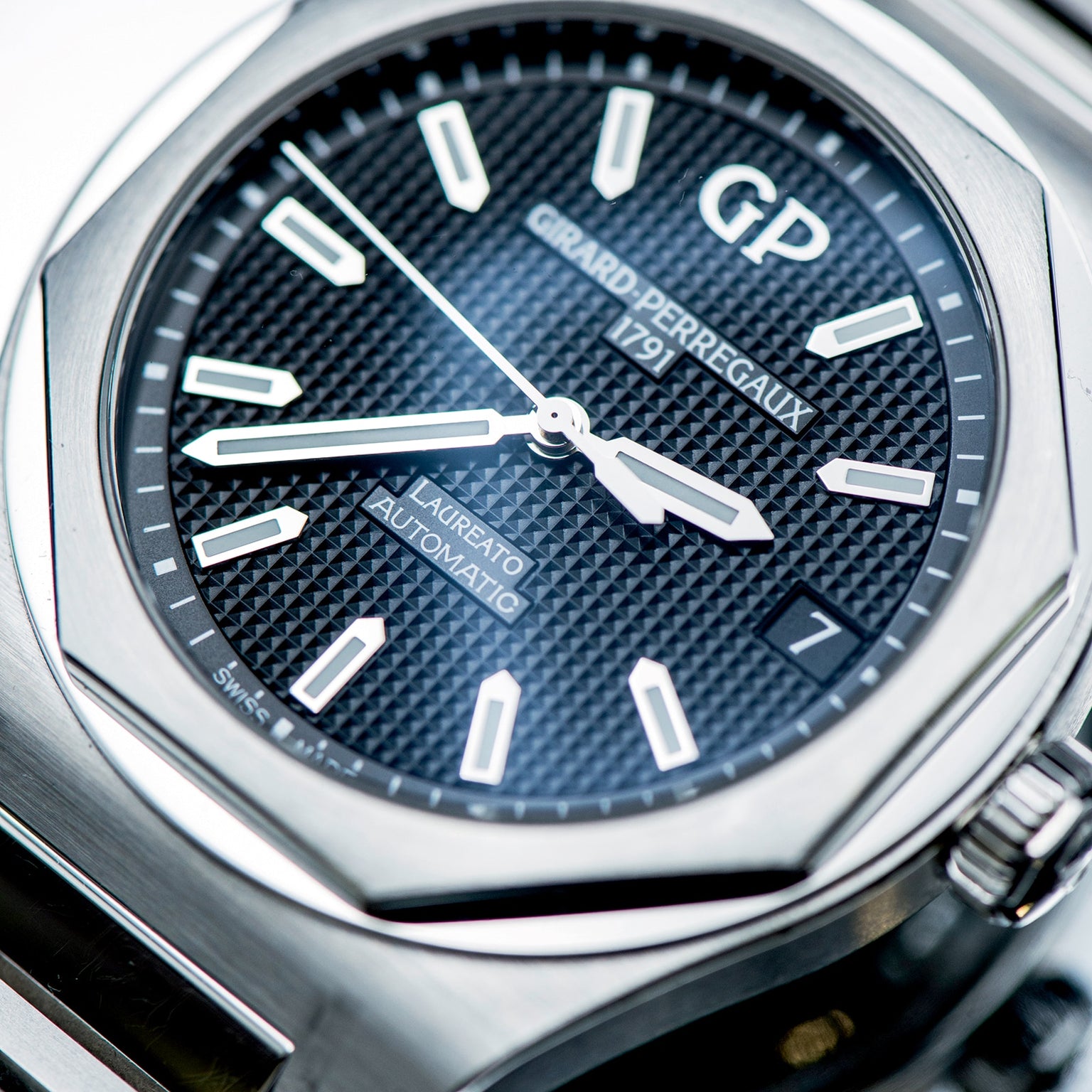 Close-up of the Girard-Perregaux Laureato 42, showcasing its black textured dial, silver hands and markers, date window at 3 oclock, and octagonal bezel on a 42mm stainless steel case.