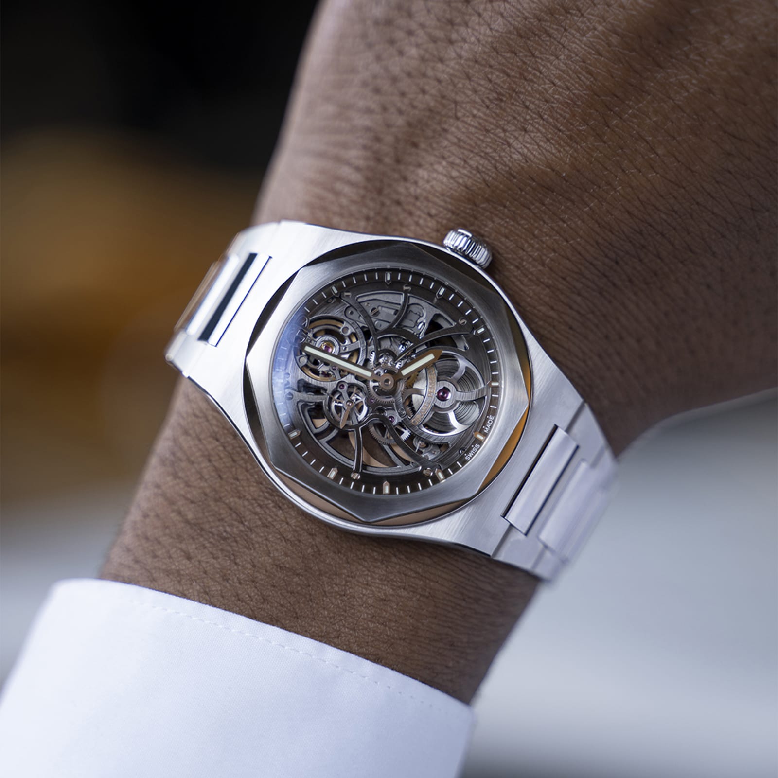 A close-up of a person wearing the Girard-Perregaux Laureato Skeleton wristwatch, featuring a silver skeleton dial with visible gears, an octagonal bezel, and a stainless steel band.