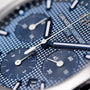 Close-up of the Girard-Perregaux Laureato Chronograph 42, highlighting its blue textured dial, octagonal bezel, subdials, silver hands, and prominent branding.