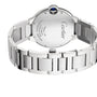 A close-up of the Cartier Ballon Bleu de Cartier steel case shows the engraved logo, specs, and signature blue cabochon crown on this self-winding mechanical wristwatch.