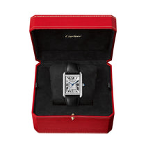 The Cartier Tank Must de Cartier wristwatch with a rectangular face, silvered dial, and black calfskin strap is displayed in an open red Cartier box with a black interior.