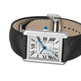 The Tank Must de Cartier is a mechanical watch featuring a rectangular silver case, silvered flinqué dial, black Roman numerals, blue hands, black calfskin strap, and a blue gem-set crown.