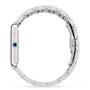 Side view of a silver Cartier Tank Américaine watch with a blue crown, mechanical movement, and linked bracelet, displayed against a plain white background.