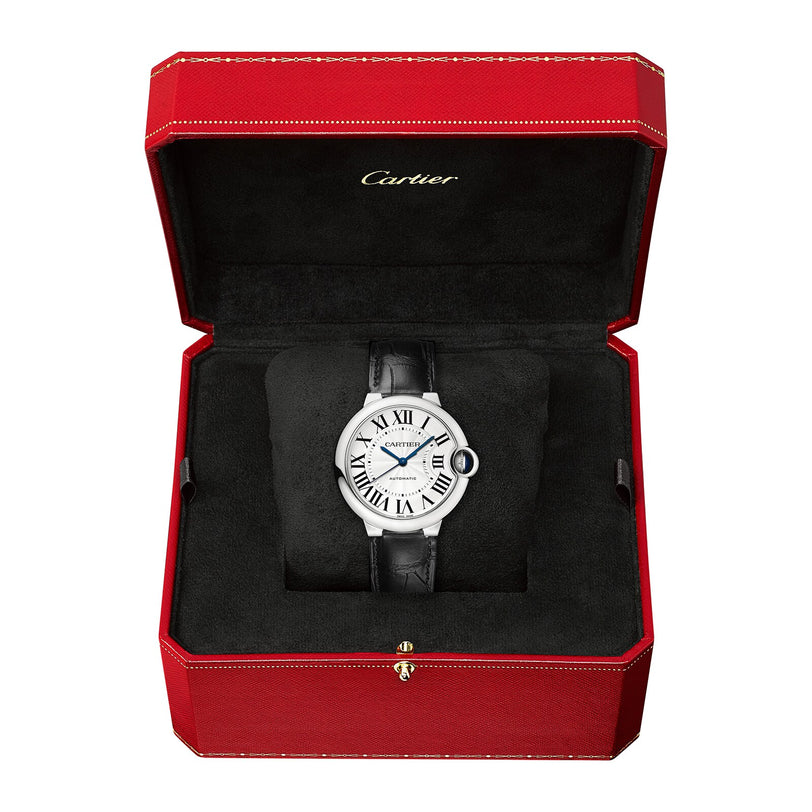 A Cartier Ballon Bleu de Cartier wristwatch with an alligator leather strap and Roman numeral dial is displayed in an open red and black Cartier box.
