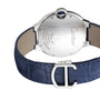 A close-up of the Ballon Bleu de Cartier watch by Cartier showcases its engraved back, blue leather strap, and signature C-shaped clasp.