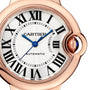 Close-up of the Cartier Ballon Bleu de Cartier watch featuring a white dial, black Roman numerals, blue hands, and a rose gold case with a cabochon sapphire crown.